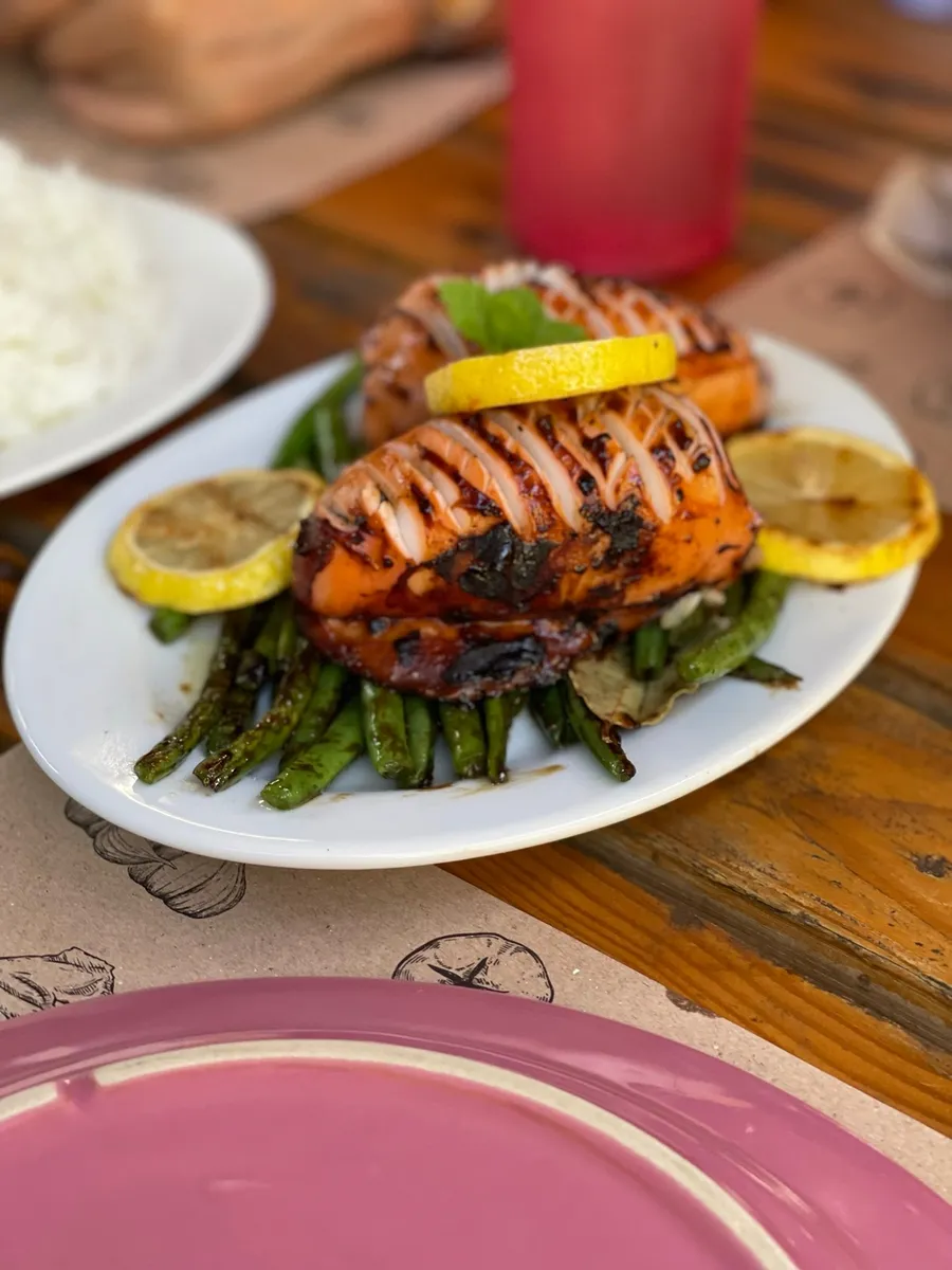 Grilled squid with lemon on a plate of grilled string beans